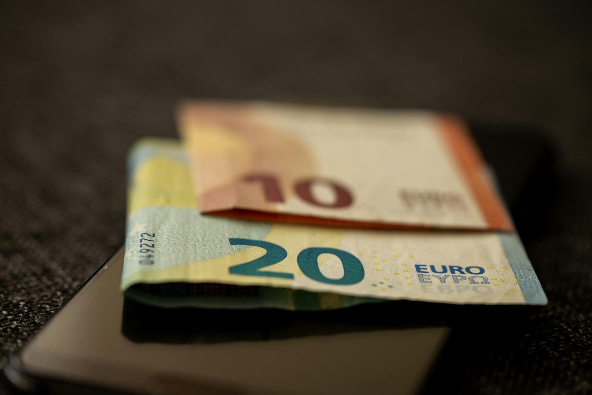 Euro-Scheine auf Smartphone — Embedded Finance und digitale Finanzprodukte