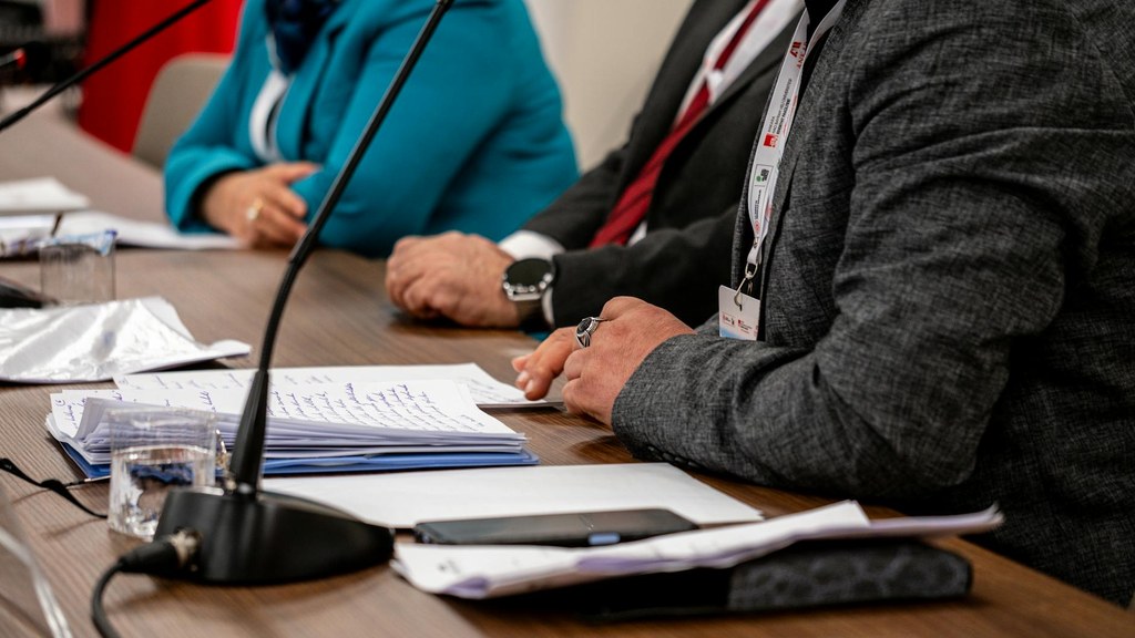Aufnahme von zwei Personen im Anzug in einem Innenraum in Ankara zeigt ein professionelles Gespräch in Bürosituation.