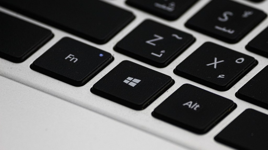 Aufnahme von Abdelrahman Ahmed zeigt eine Detailansicht einer Laptoptastatur und eines Bildschirms mit Notepad++-Fenster und Update-Dialog im Hintergrund, daneben ein Kaffeebecher und ein Zettel.